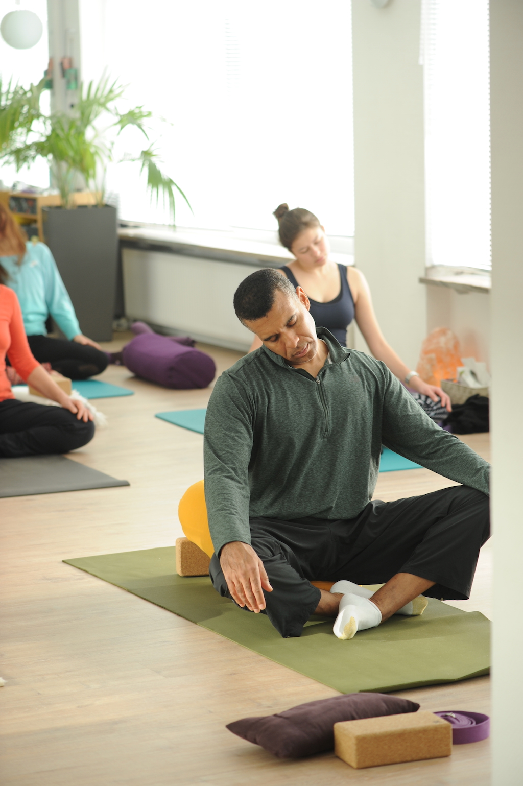 business Teilnehmer sitzt im Yogasitz auf seiner Matte